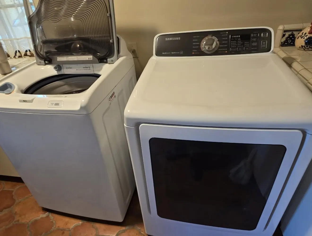 A top-loading washing machine and tumble dryer