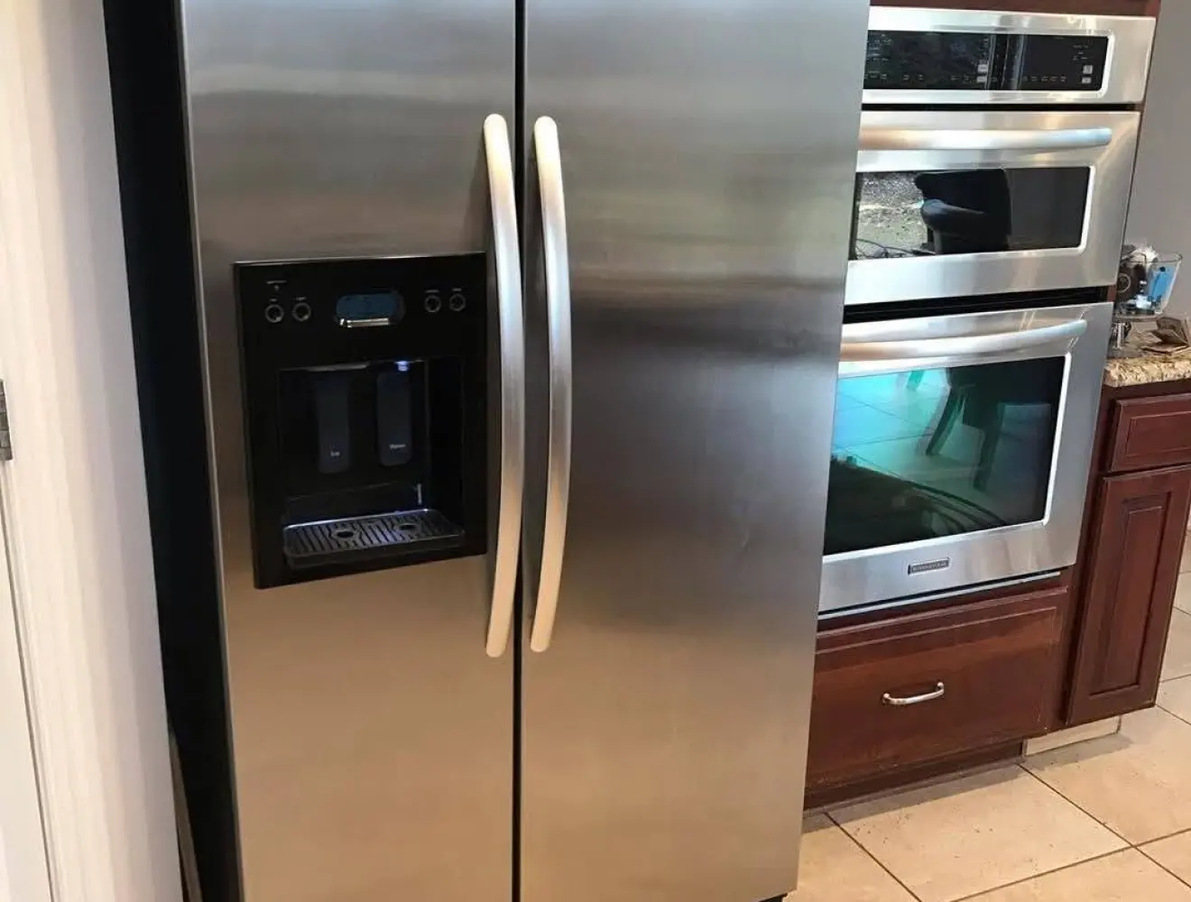 A stainless steel fridge and built-in ovens in a kitchen